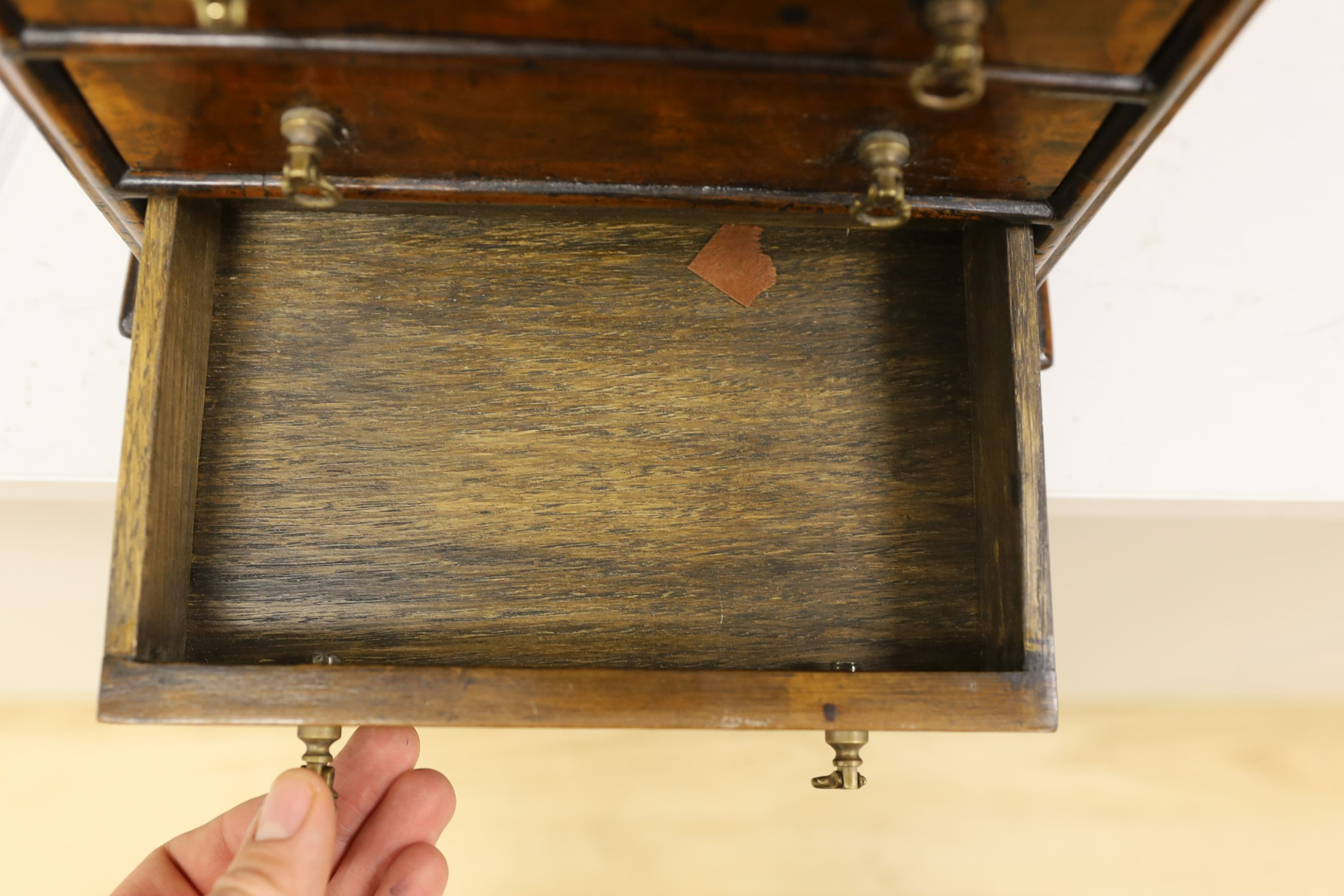 A cross banded walnut miniature chest of three drawers, 26cm wide